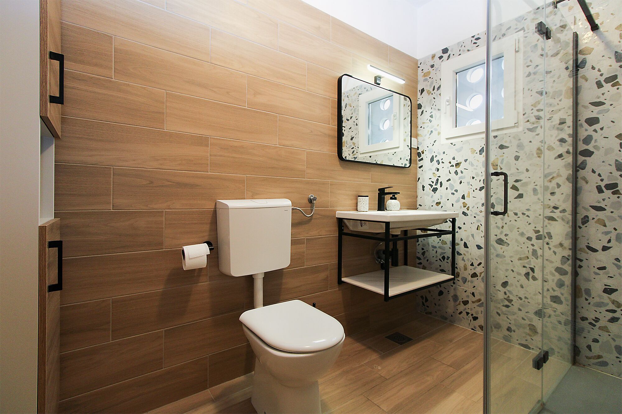 A modern bathroom with a toilet, sink, and shower.