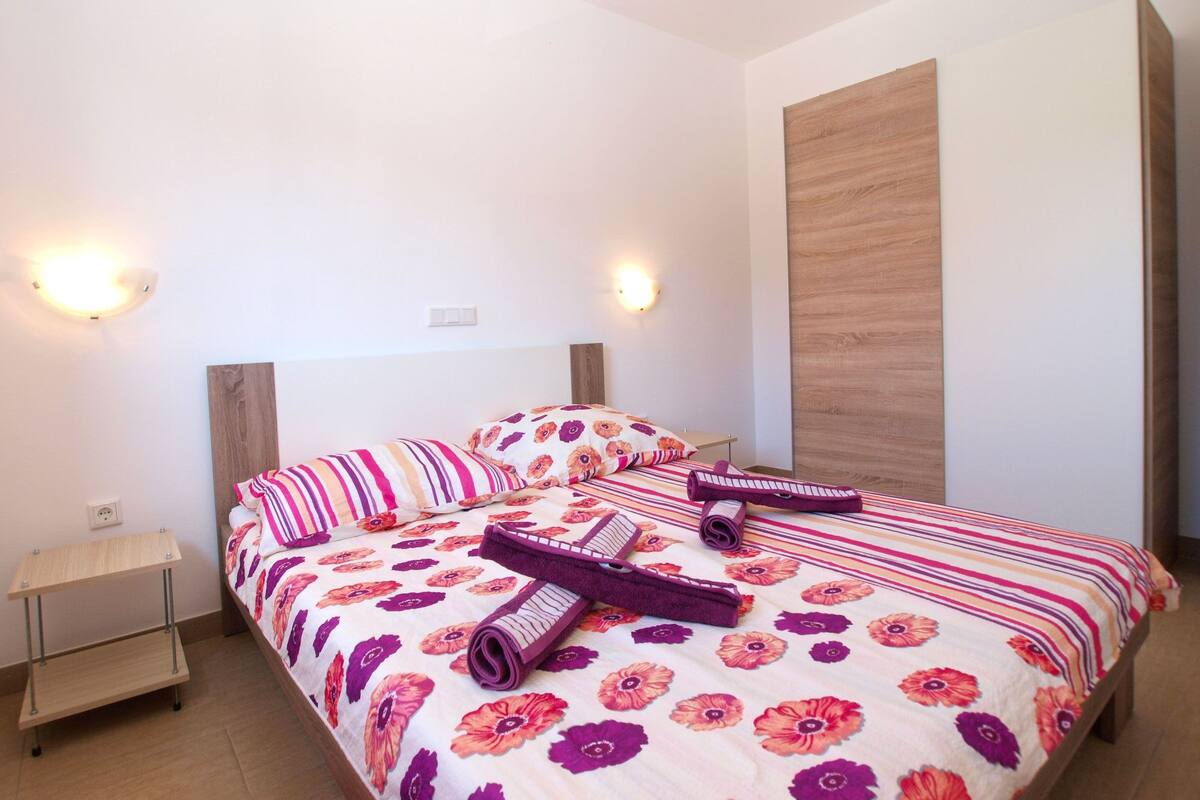 Ein Schlafzimmer mit einem Bett, zwei Nachttischen und zwei Wandleuchten.