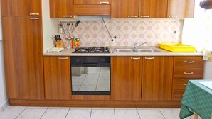Una cucina compatta con mobili in legno, un piano cottura a gas, una lavastoviglie e un lavello.