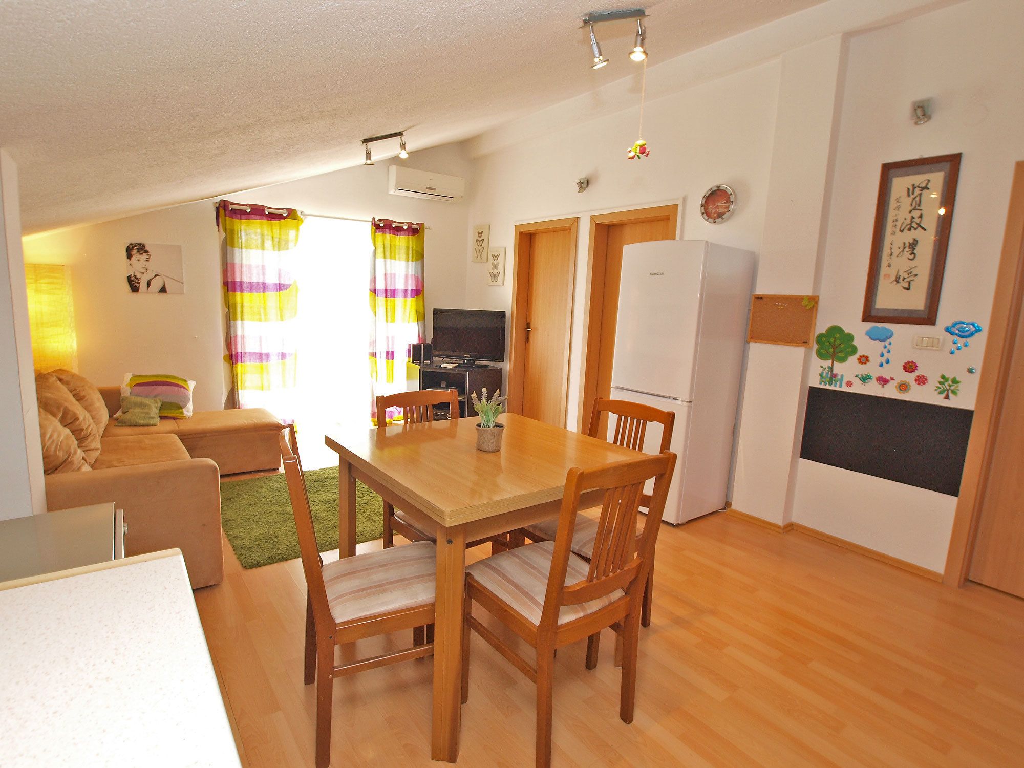 A compact living space with a dining area, sofa, and a kitchenette.