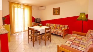A living room with a dining table, sofa, and TV. - Apartments Marina 947 (Fazana)