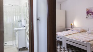 Un dormitorio con piso a cuadros, una cama, una mesita de noche y una lámpara de noche.