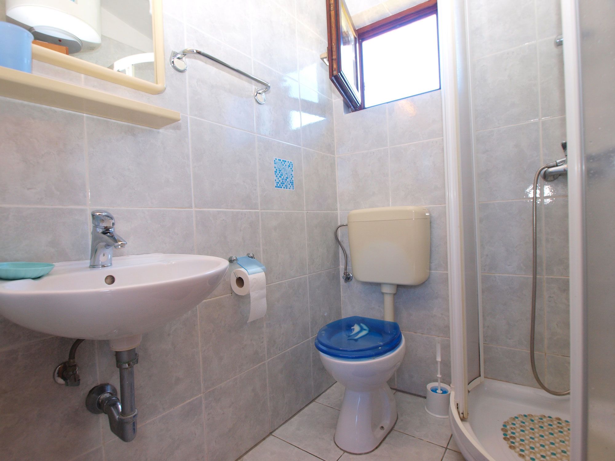 A bathroom with a sink, toilet, and shower.