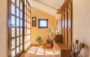 A sunlit hallway with large windows, a clock, and potted plants. - Apartments Luce 1204 (Medulin)