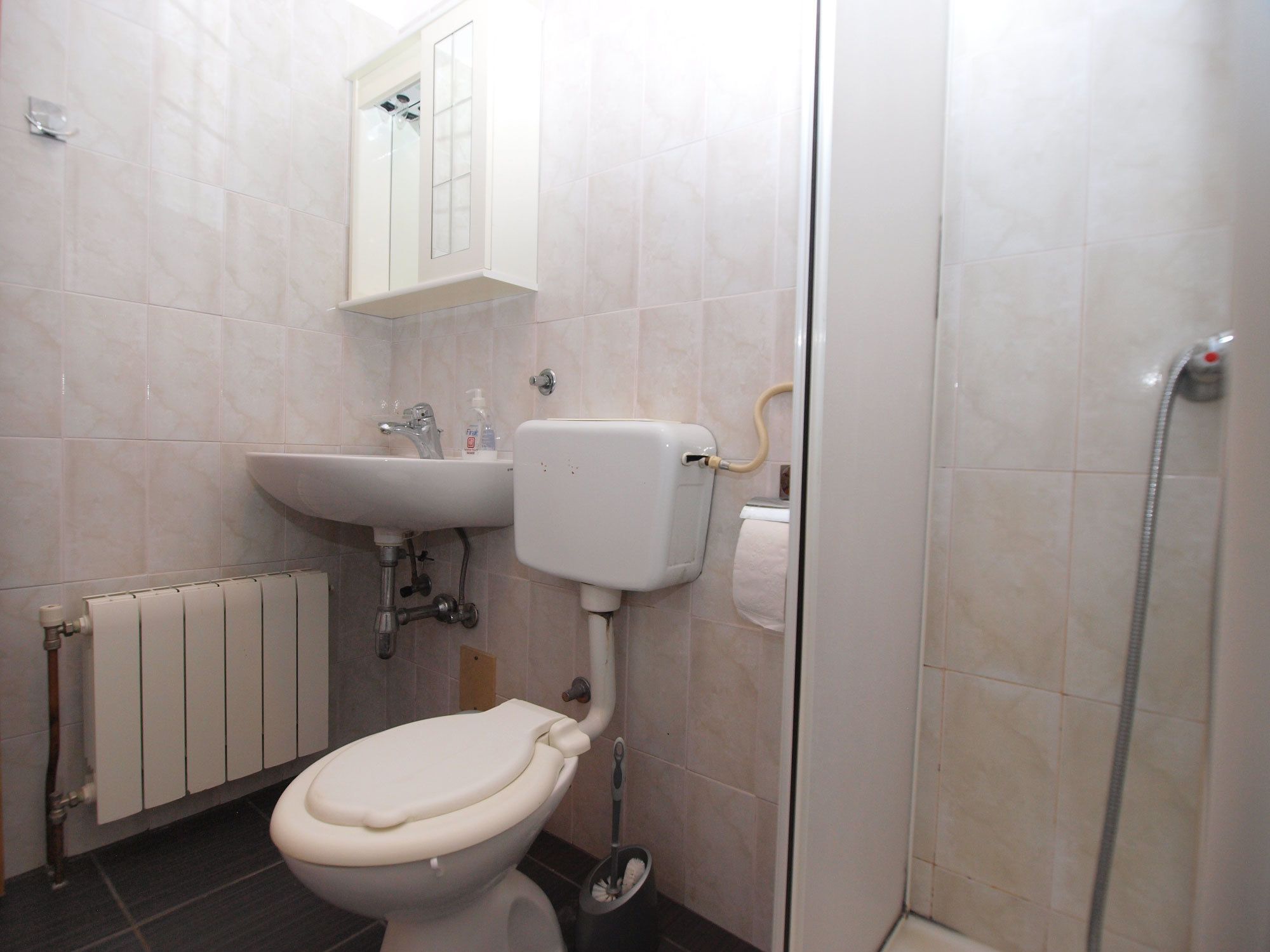 A bathroom with a toilet, sink, and shower.