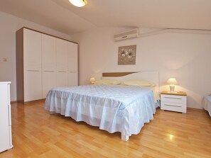 A bedroom with a bed, bedside tables, a wardrobe, and an air conditioning unit. - Apartments Lean 1048 (Rovinj)
