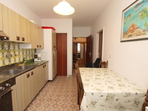 A compact kitchen with a refrigerator, sink, and a dining area with a table.