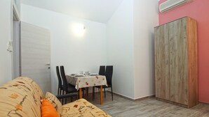 A small, compact room with a dining area, a sofa, and a wardrobe. - Apartments Orijana 898 (Pula)