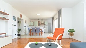 A modern living room with a white table, orange armchair, and a blue sofa. - Apartments Emil 596 (Pula)
