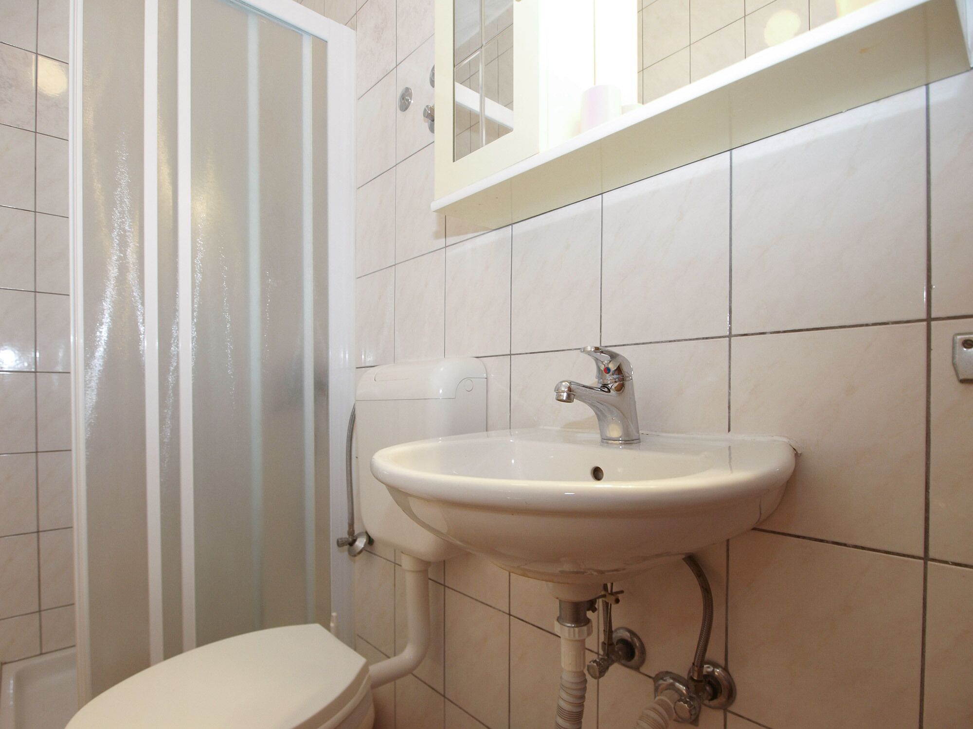 A bathroom with a toilet, sink, and shower.