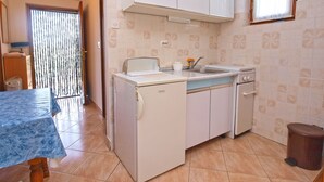 A compact kitchen with a built-in washing machine, a sink, and a stove. - Apartments Marta 1066 (Rovinj)