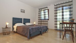 Une chambre à coucher avec un lit, des lampes de chevet, une petite table et une chaise.