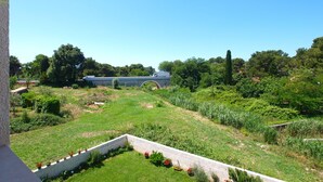 Un jardin aménagé avec un mur en pierre et des plantes en pot.