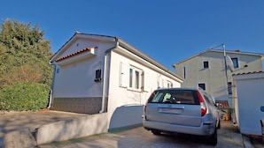 A residential area with a white house, a parked silver car, and a clear blue sky. - Apartments Jacqueline 1227 (Medulin)
