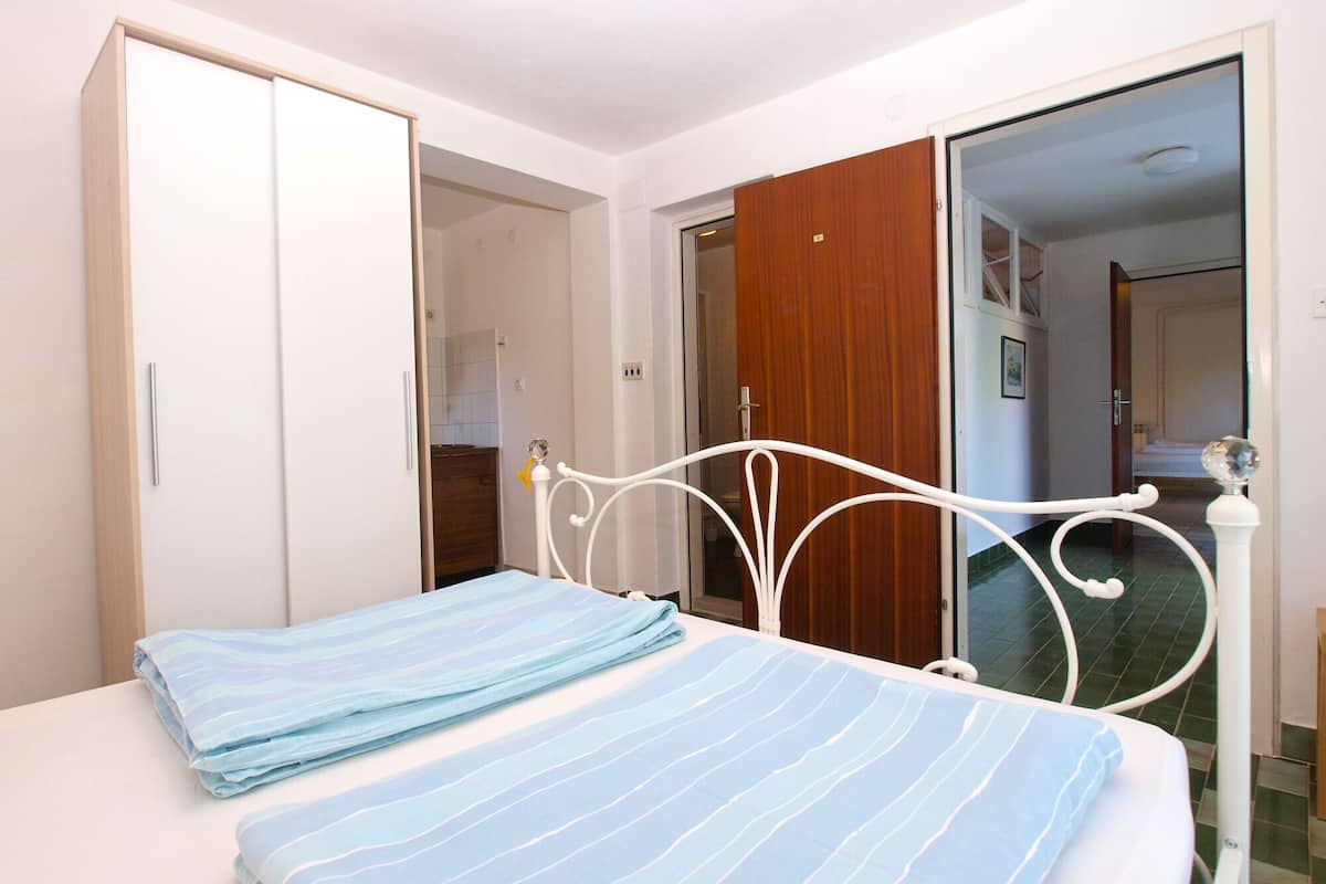 A bedroom with a bed, a wardrobe, and a bathroom door.