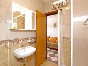 Un bagno con lavandino, specchio e doccia.