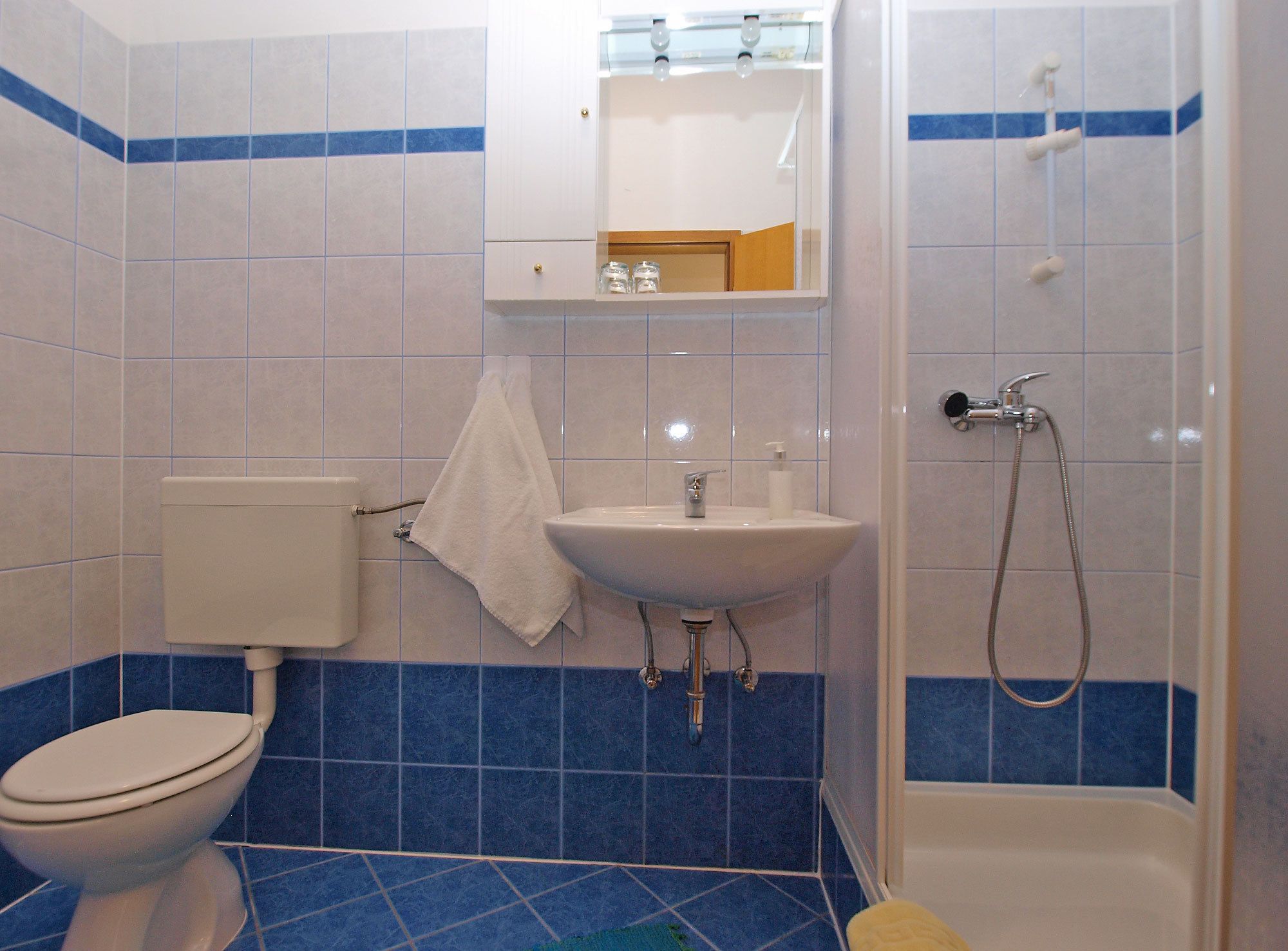 A bathroom with a toilet, sink, and shower.