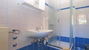 Ein Badezimmer mit Waschbecken, Spiegel und Dusche.