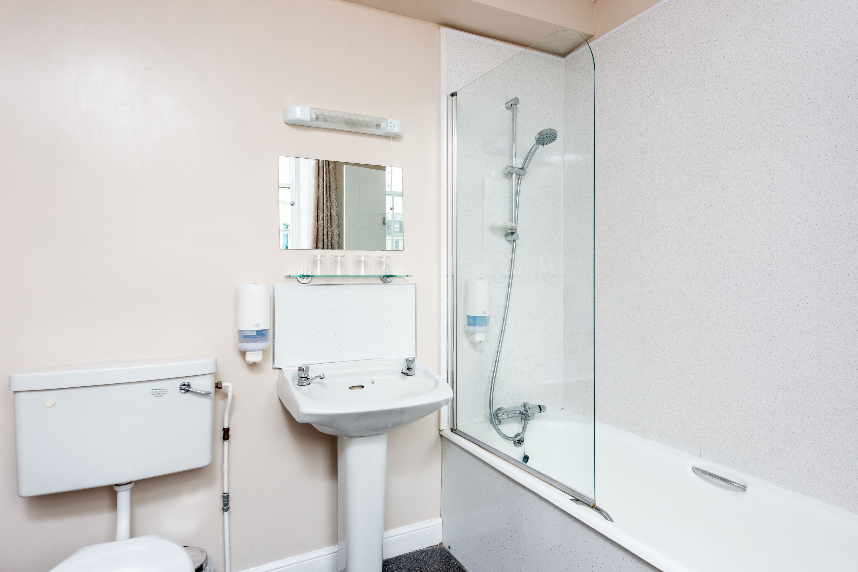 Ein Badezimmer mit Toilette, Waschbecken und einer Duschkabine.