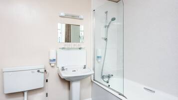 A bathroom with a toilet, sink, and glass-enclosed shower.