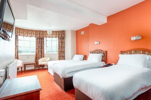 A hotel room with two beds, a desk, a chair, and a TV. - The Esplanade Hotel (Scarborough)