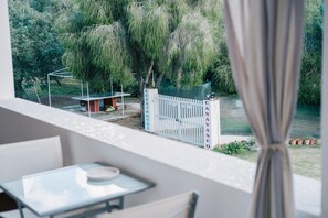 Ein Balkon mit Blick auf einen Garten und ein Tor mit der Aufschrift 'GUEST HOUSE'.