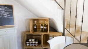 Una botellera de madera con botellas y frascos, una pizarra con texto y una escalera.