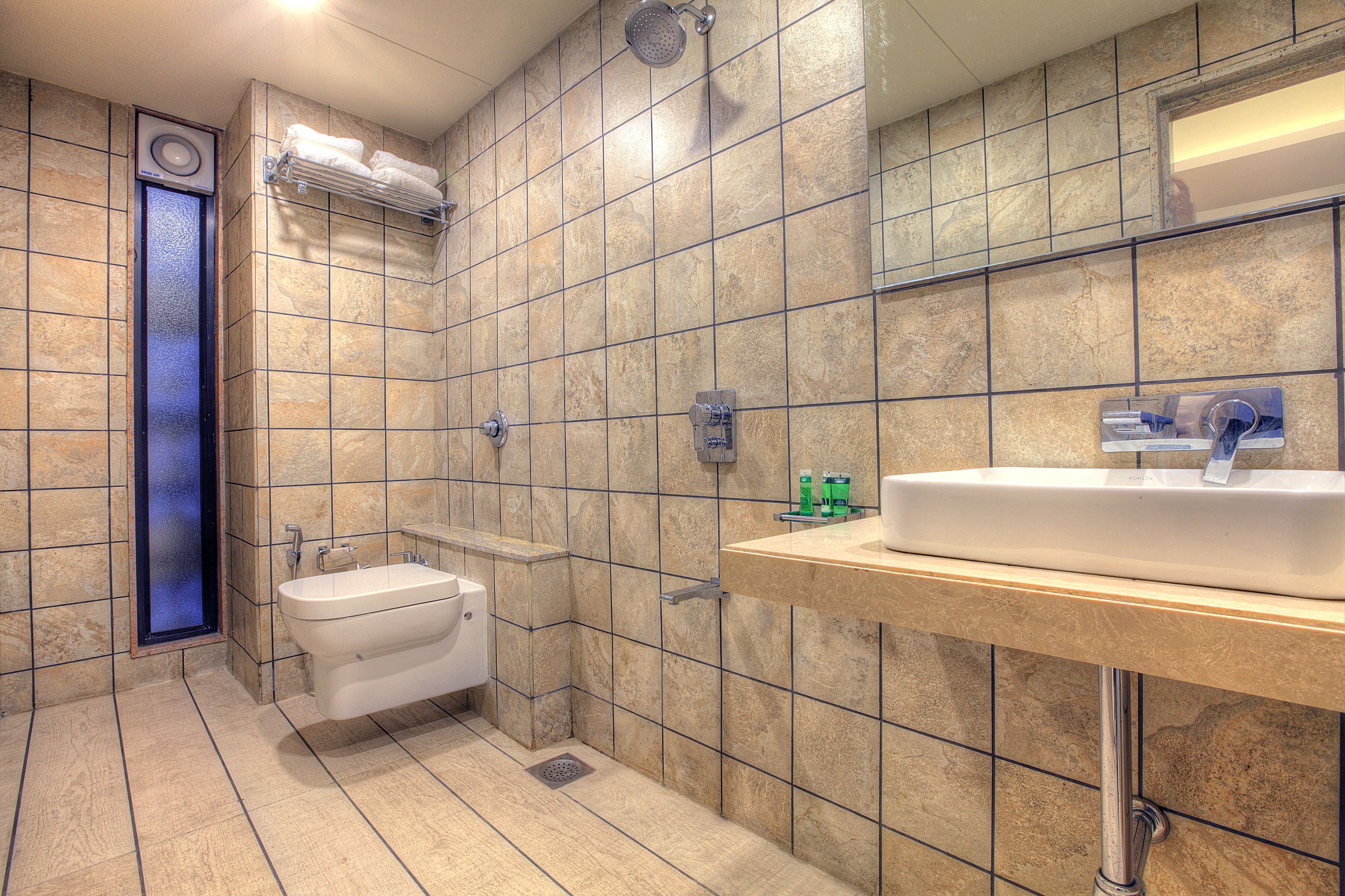 A modern bathroom with a sink, toilet, and shower.