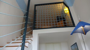 Un escalier avec des rampes bleues et une grille en métal au sommet.