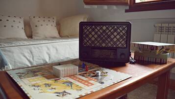 Un juego de mesa sobre una mesa de madera, con una cama y almohadas al fondo.