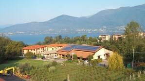 Zona residencial con casas equipadas con paneles solares, un lago y montañas al fondo.