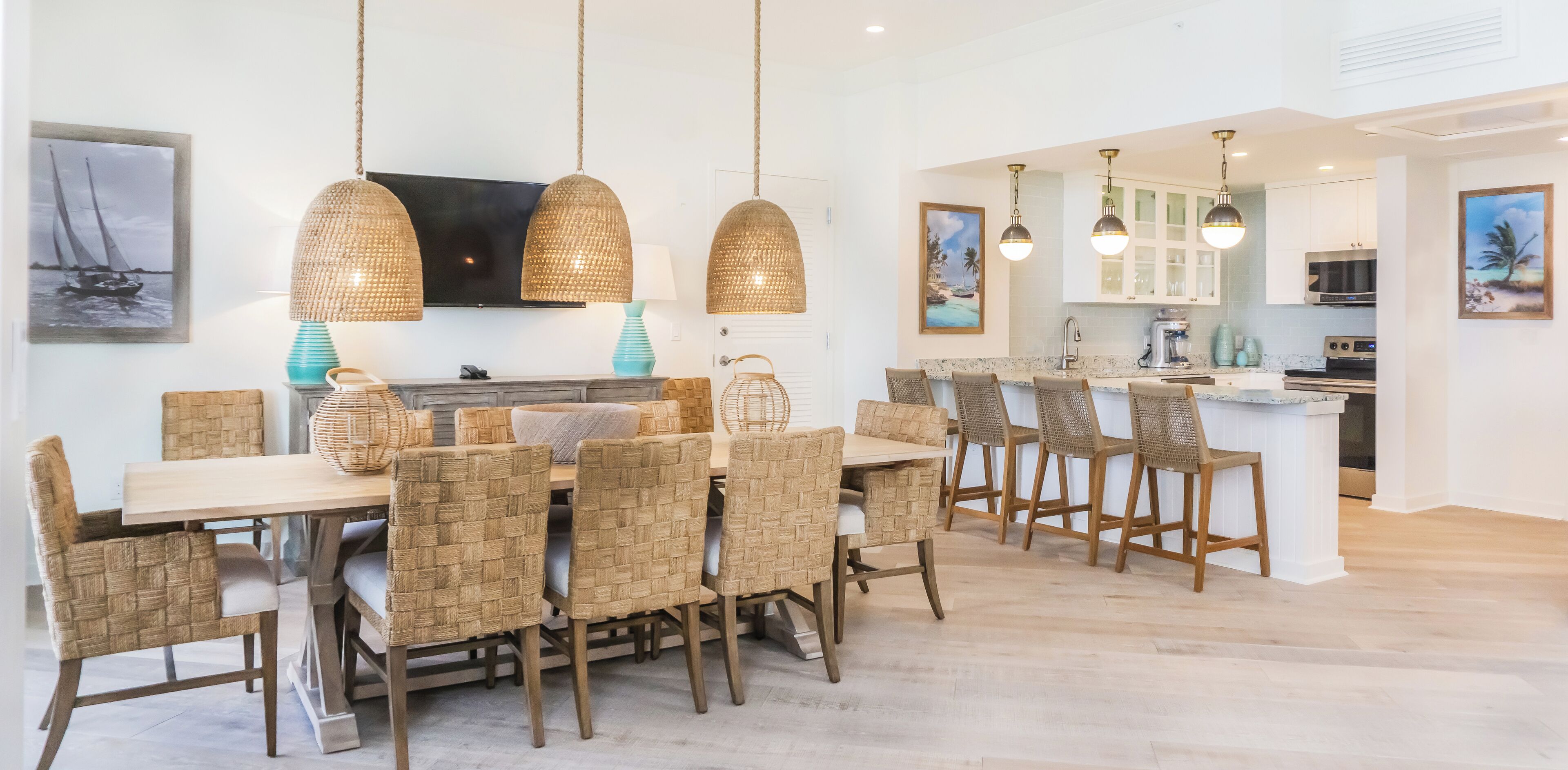 Een moderne keuken met witte kastjes, een centraal eiland en hangende hanglampen.