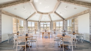 A spacious dining area with hexagonal ceiling and large windows offering views of the city.