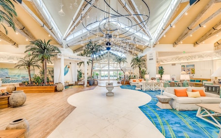 A spacious lobby with a high ceiling, wooden beams, and a central fountain.