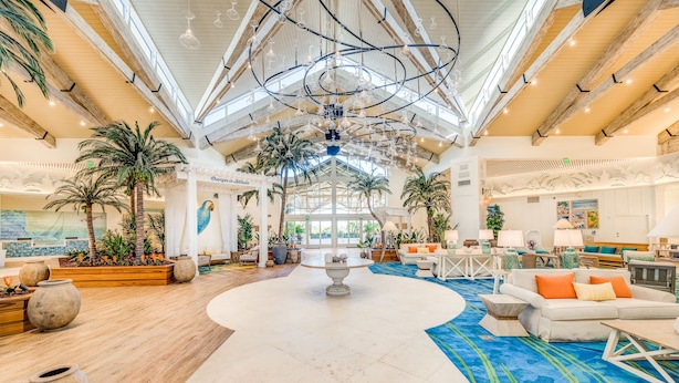 A spacious lobby with a high ceiling, wooden beams, and a central fountain.