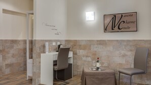 Una habitación de hotel moderna con comedor, minibar y un letrero en la pared.
