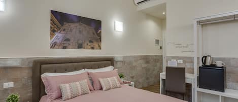 A neatly arranged bedroom with a large bed, a desk, and a chair.
