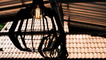 Un luminaire suspendu dont l’ampoule est visible.