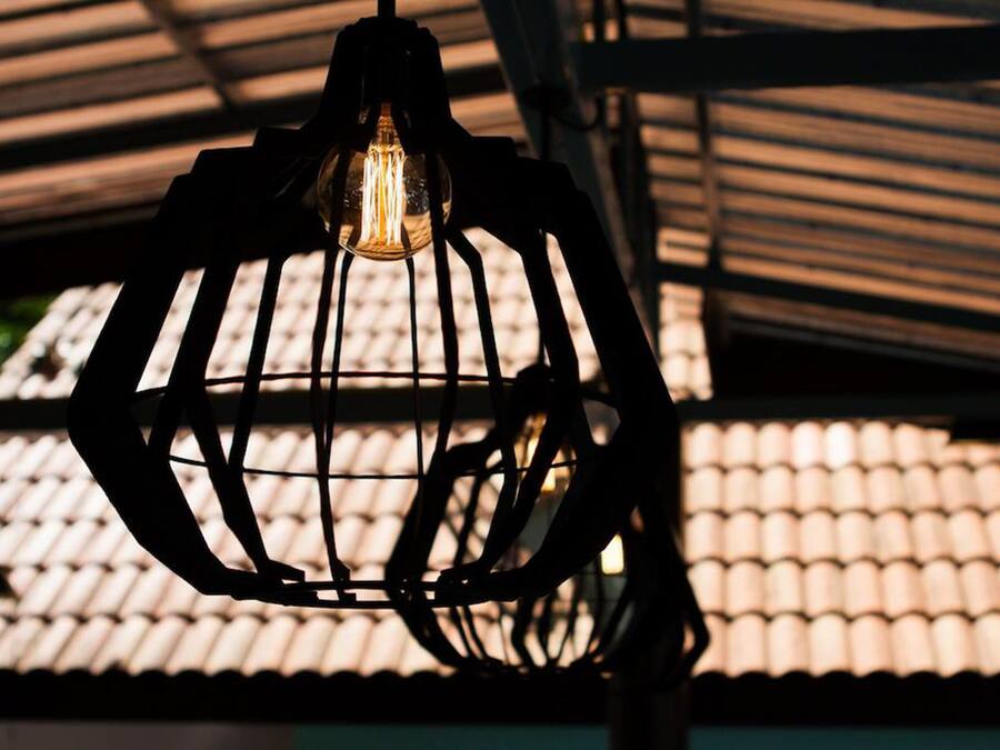 Un luminaire suspendu dont l’ampoule est visible.