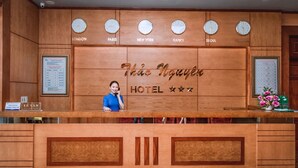 A hotel reception desk with clocks indicating different cities and a sign reading "This Nguyen Hotel". - Thao Nguyen Hotel (Thao Nguyen)