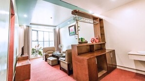 A modern living room with a sofa, a coffee table, a TV mounted on the wall, and a wooden cabinet. - Thao Nguyen Hotel (Thao Nguyen)