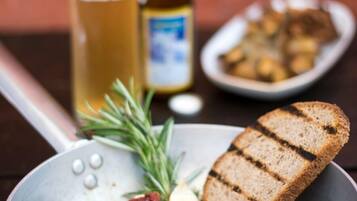 Un repas composé de viande grillée, de pain et d’un verre de bière, le tout servi sur une table.