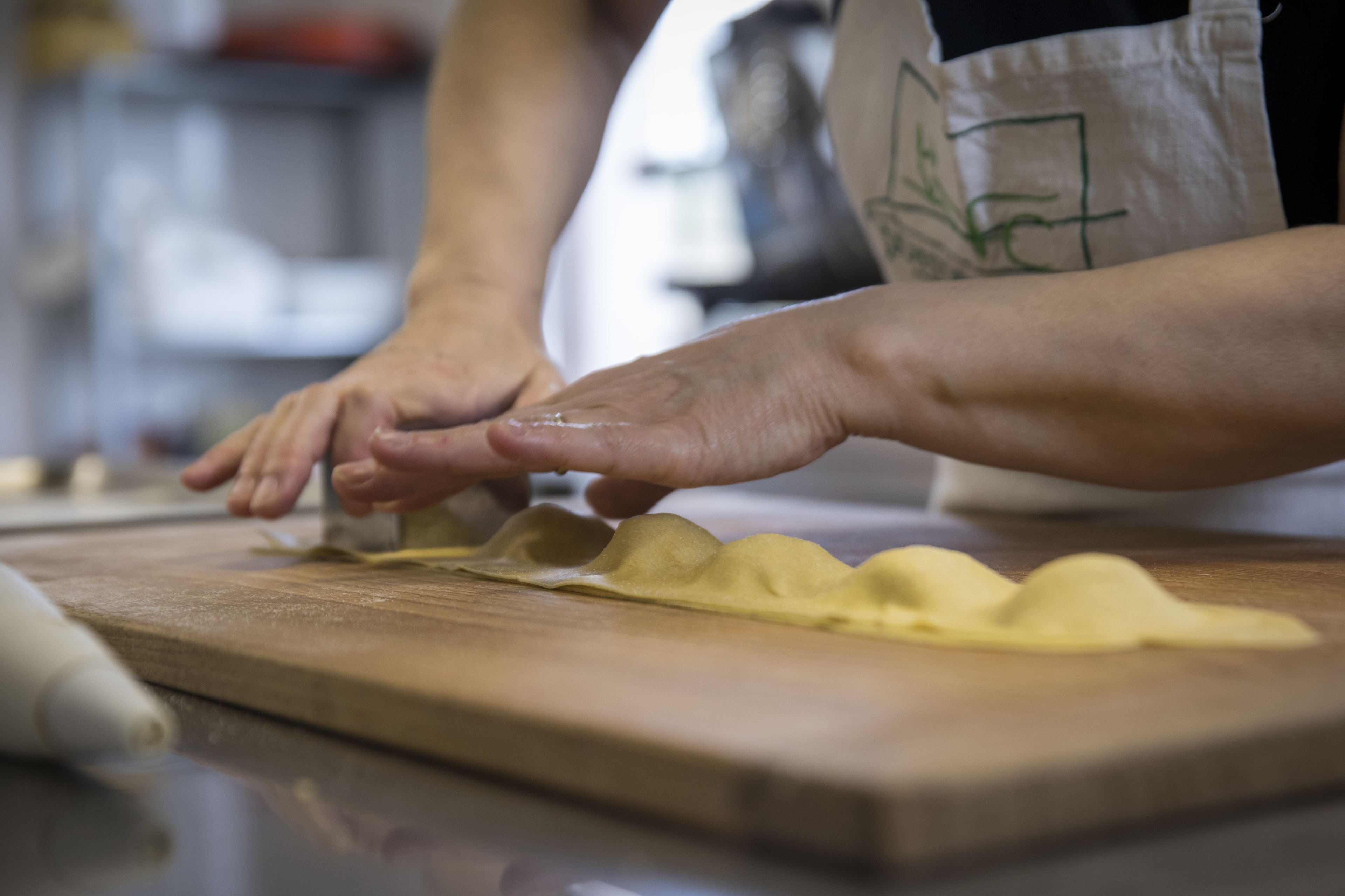 Une personne préparant des aliments sur une planche à découper en bois.