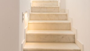 A staircase with a white wall and a skylight at the top. - imarkellis boutique villas (Tinos)