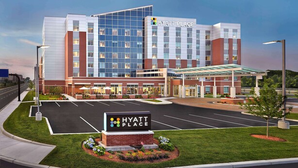 Un hôtel Hyatt Place moderne doté d’un grand parking, d’une pelouse bien entretenue et d’un ciel dégagé.