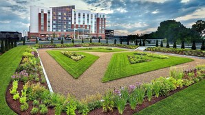 Un hôtel au design moderne, doté d’un jardin central aménagé selon des motifs géométriques et d’un espace de stationnement situé à l’avant.