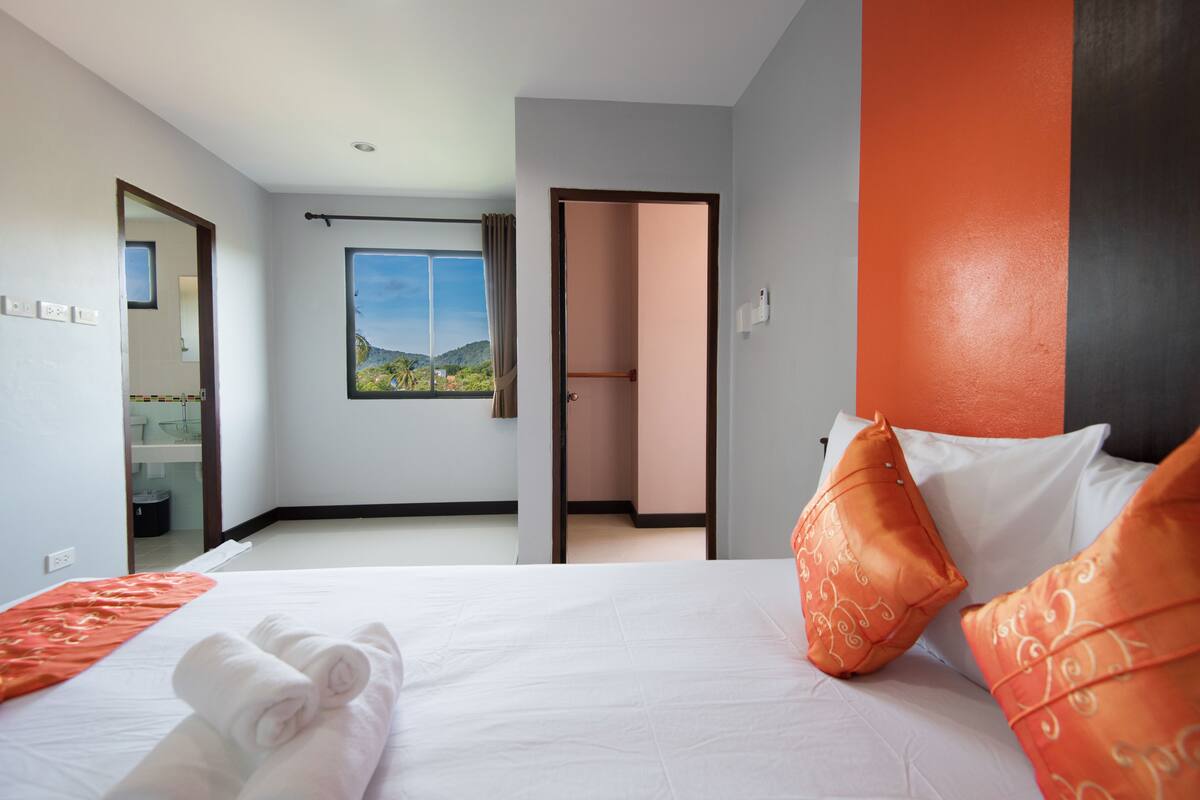 Habitación de hotel con cama, baño y vistas a un paisaje por la ventana.