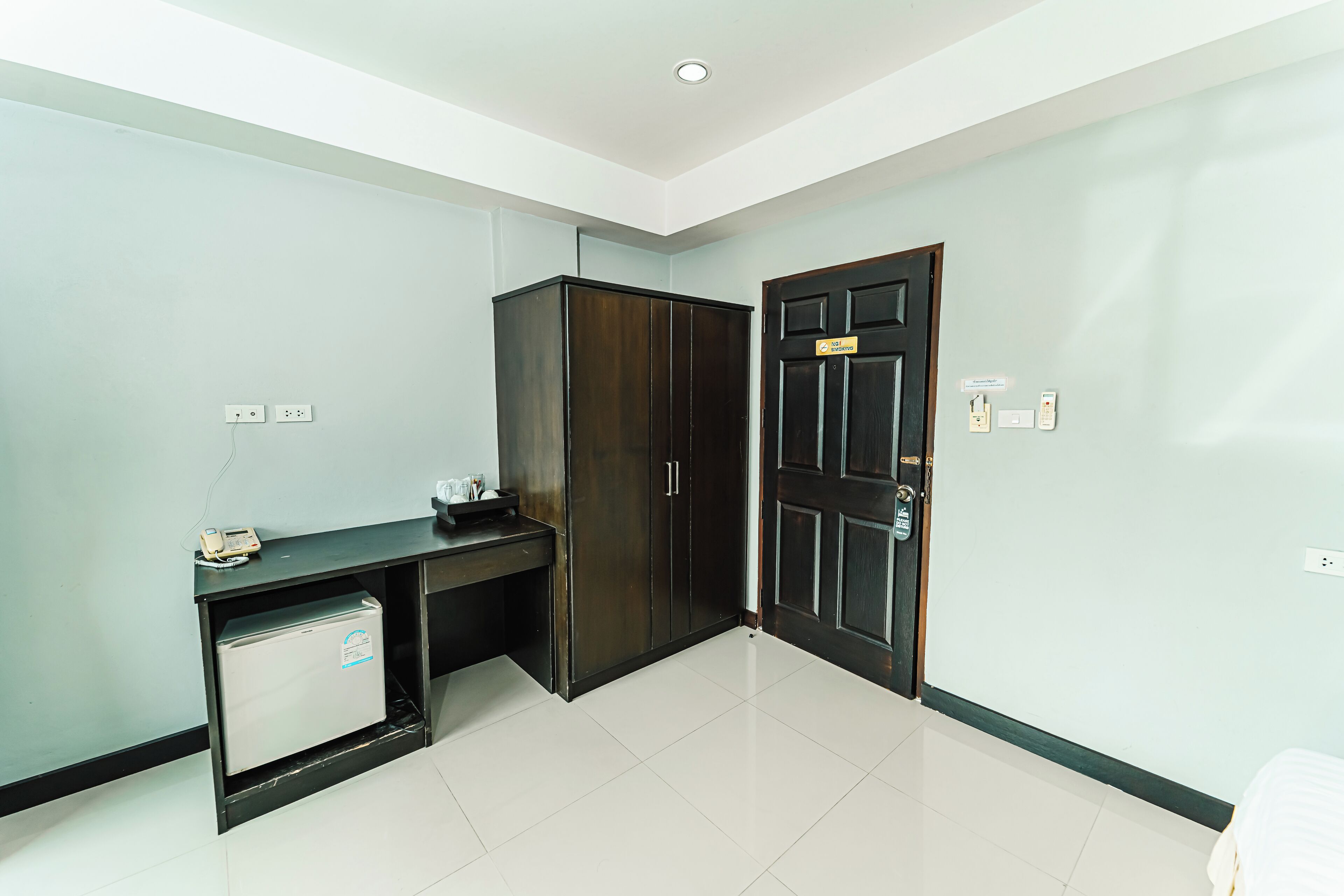A room with a desk, wardrobe, and a door with a lock.