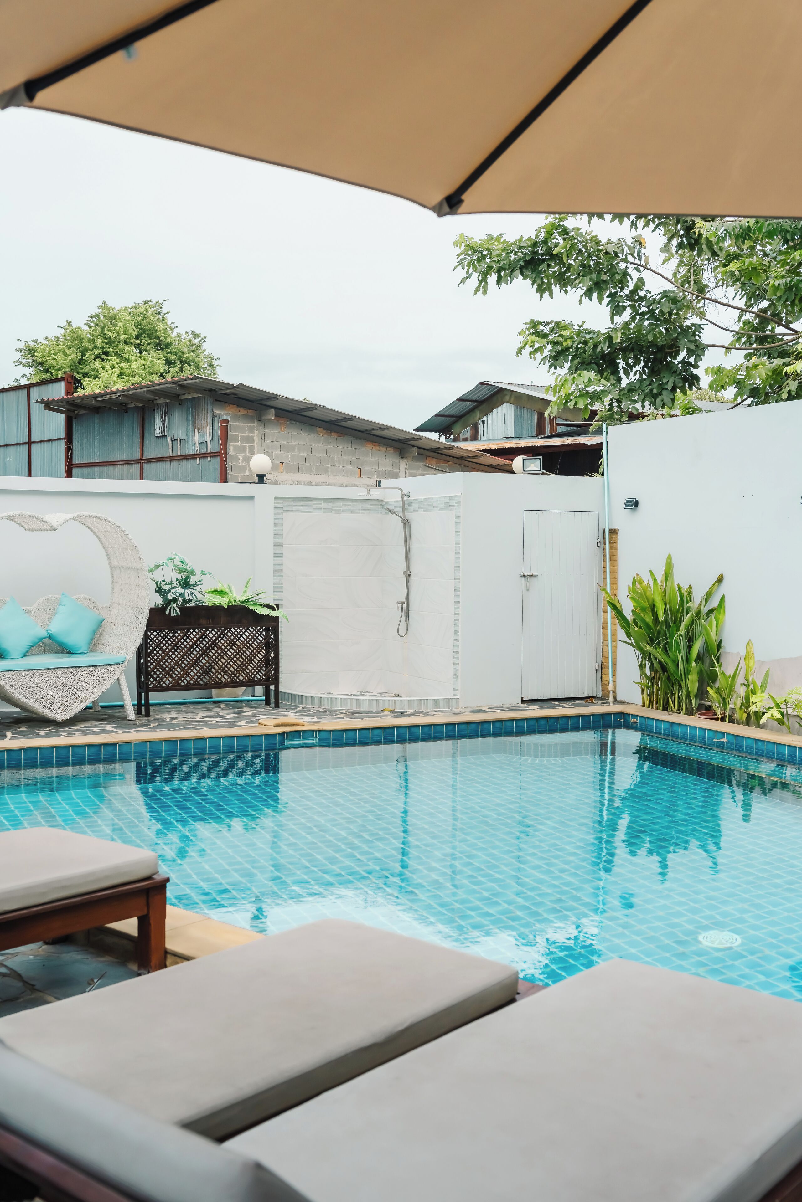 Une piscine avec des chaises longues et un espace abrité.