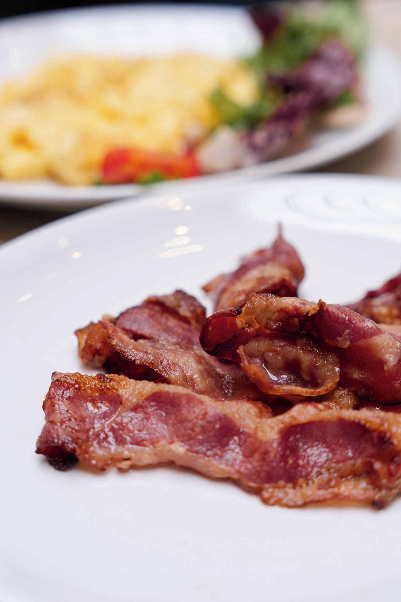 A plate of cooked bacon strips.